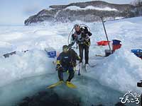 流氷に開けた穴からエントリーします。安全の為にBCにつないだロープを陸上スタッフが持っています。